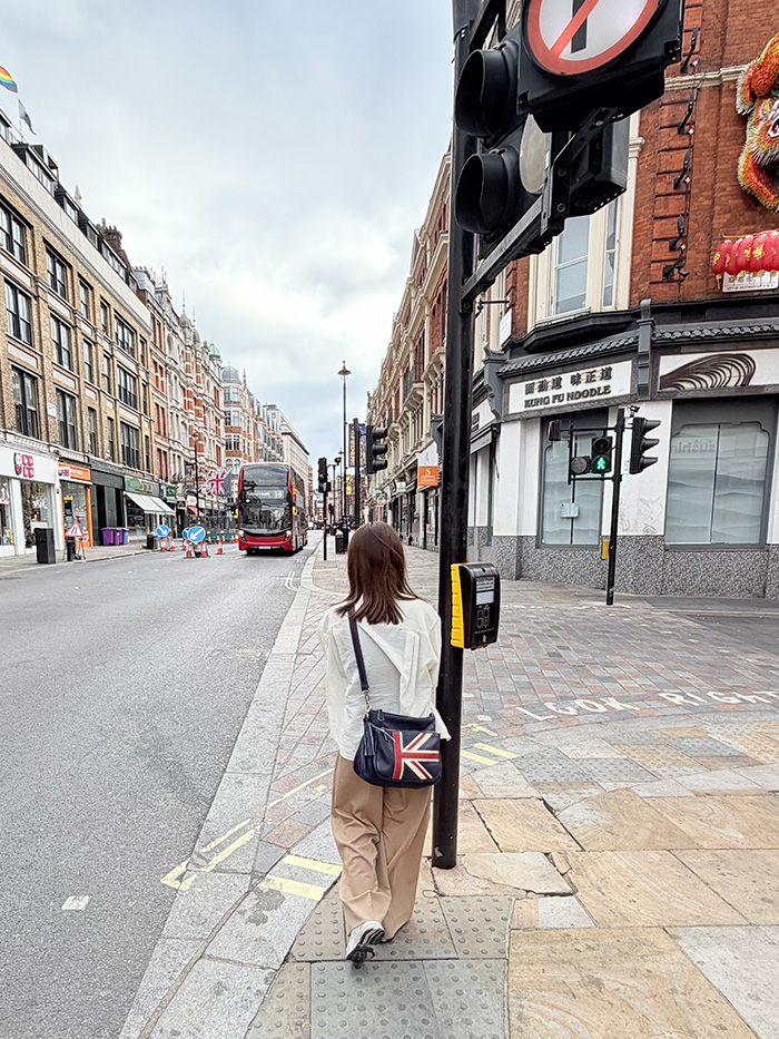 ロンドンの街を本革バッグで歩く50代女性の旅行スタイル