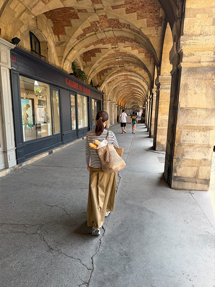 パリの街を本革トートバッグで歩く50代女性の旅行コーディネート