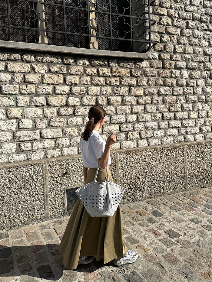 パリ旅行でレザーメッシュバッグを持つ50代女性の夏コーディネート