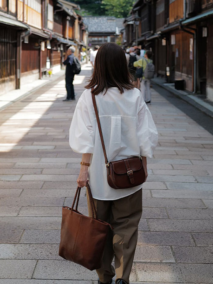 旅行先で本革トラベルバッグを持つ女性