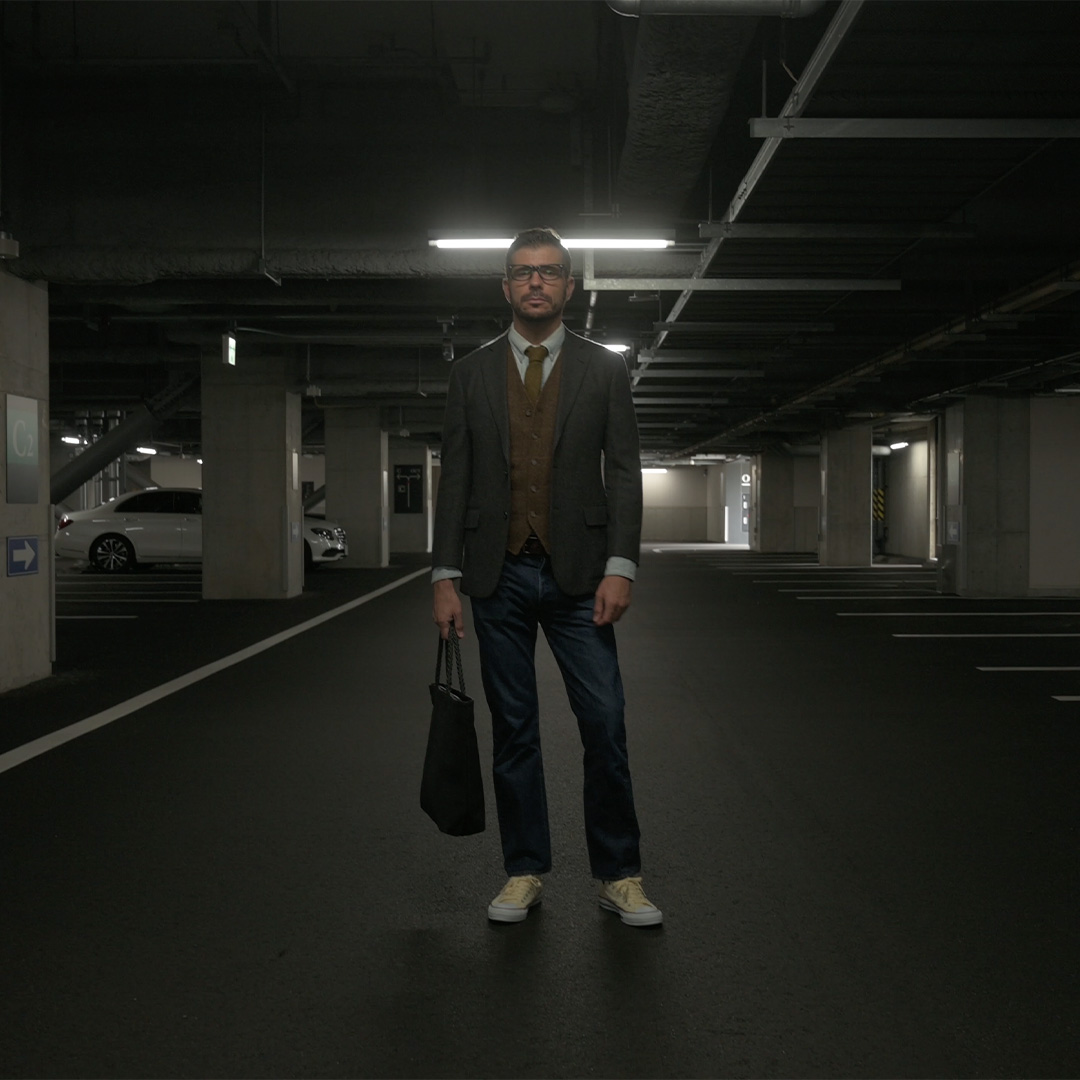 黒革に赤ステッチの本革トートバッグを持つ男性(NOIR-GTシリーズ)